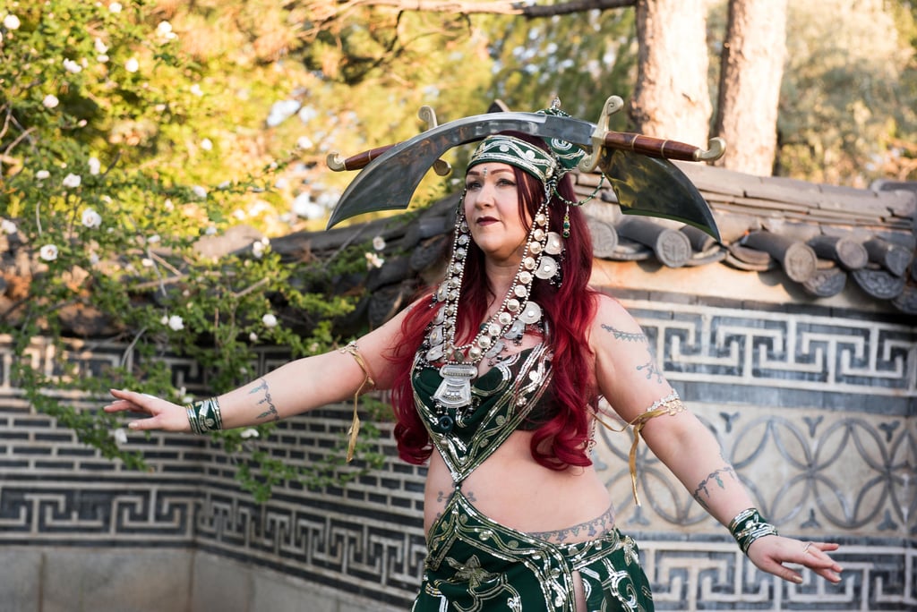 Double sword dancer Shaharvar in green costume performing at temple