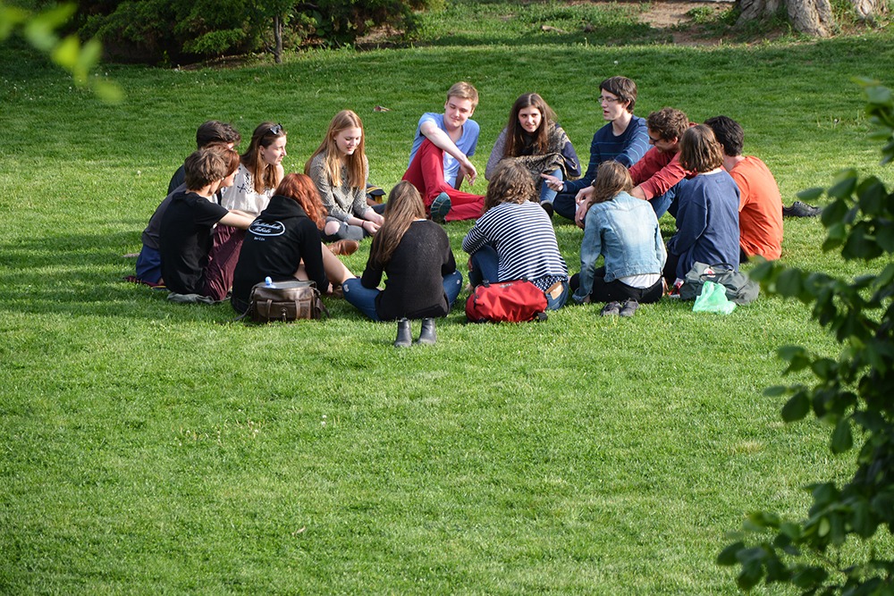 Groupe de personnes assis en cercle sur l'herbe