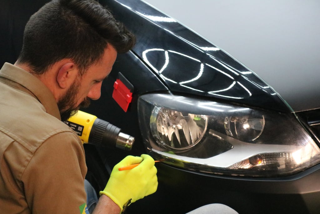 a man in a yellow glove is using a drillet to wrap car