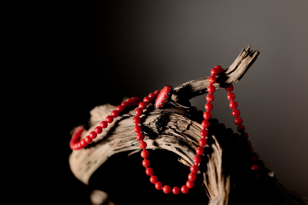 a red beaded necklace with beads on a branch