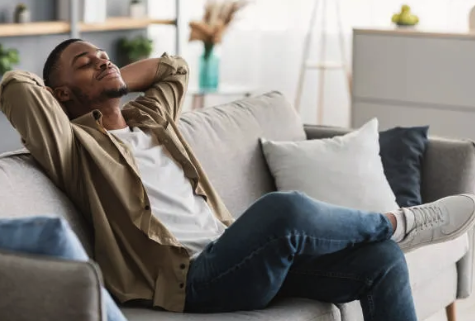 a man sitting on a couch with his head resting on his hands