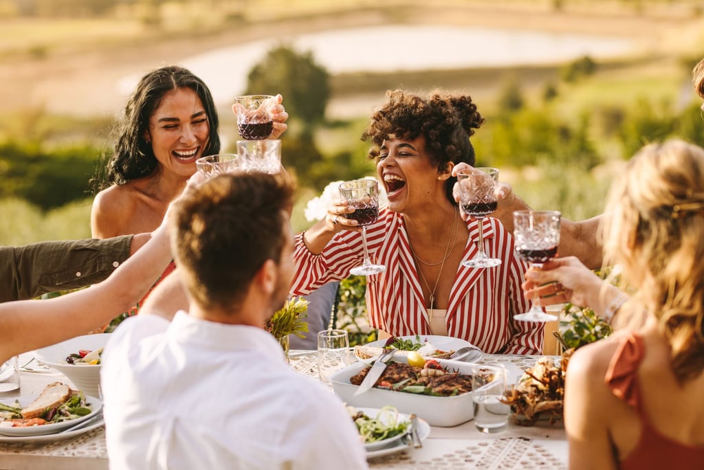 a group of people sitting around a table with wine glasses