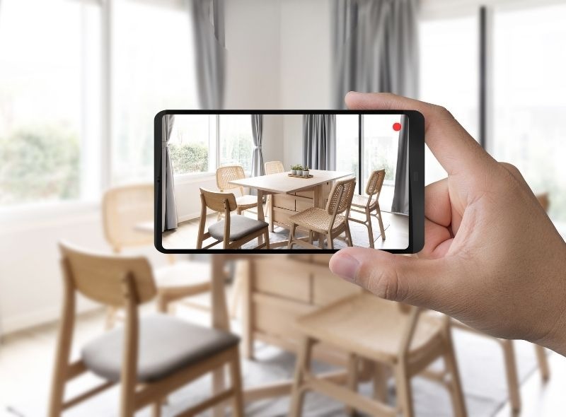 Leasing agent filming a video tour of a modern apartment to market units online.