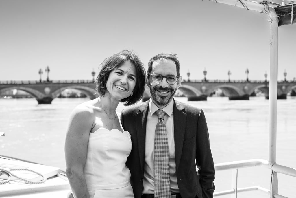des mariés sur le pont d'un bateau devant le pont de pierre de bordeaux