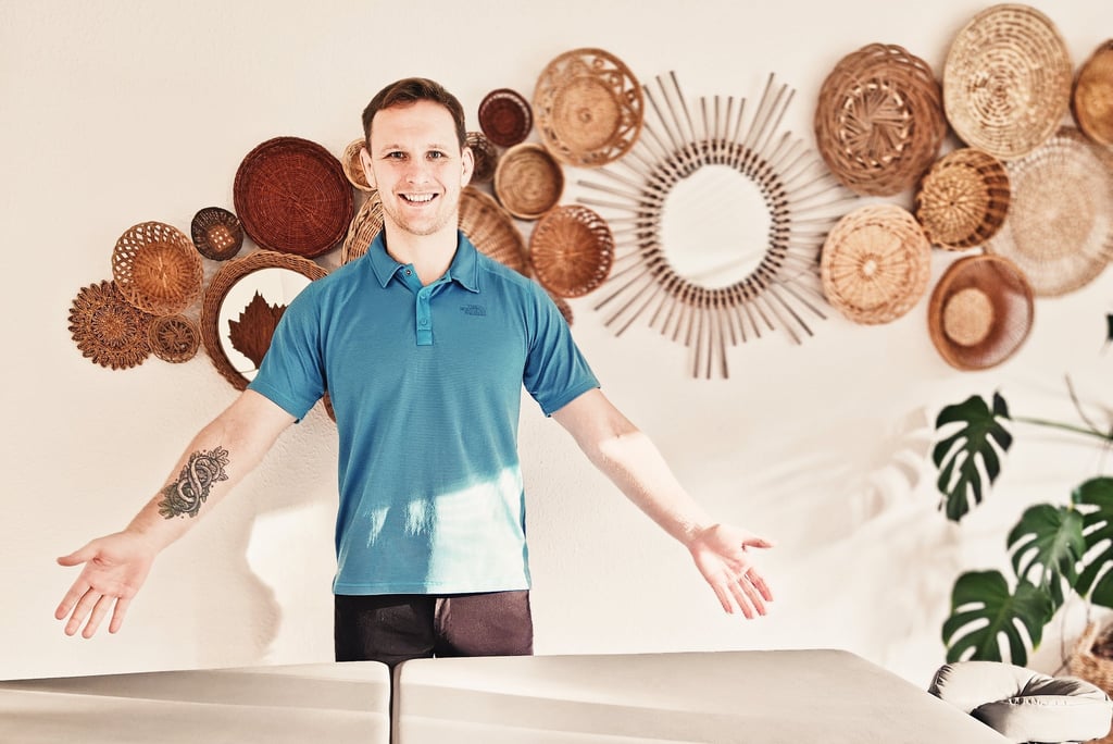 a terapist standing in front of a wall with dekoration with baskets, holistic atmosphere 