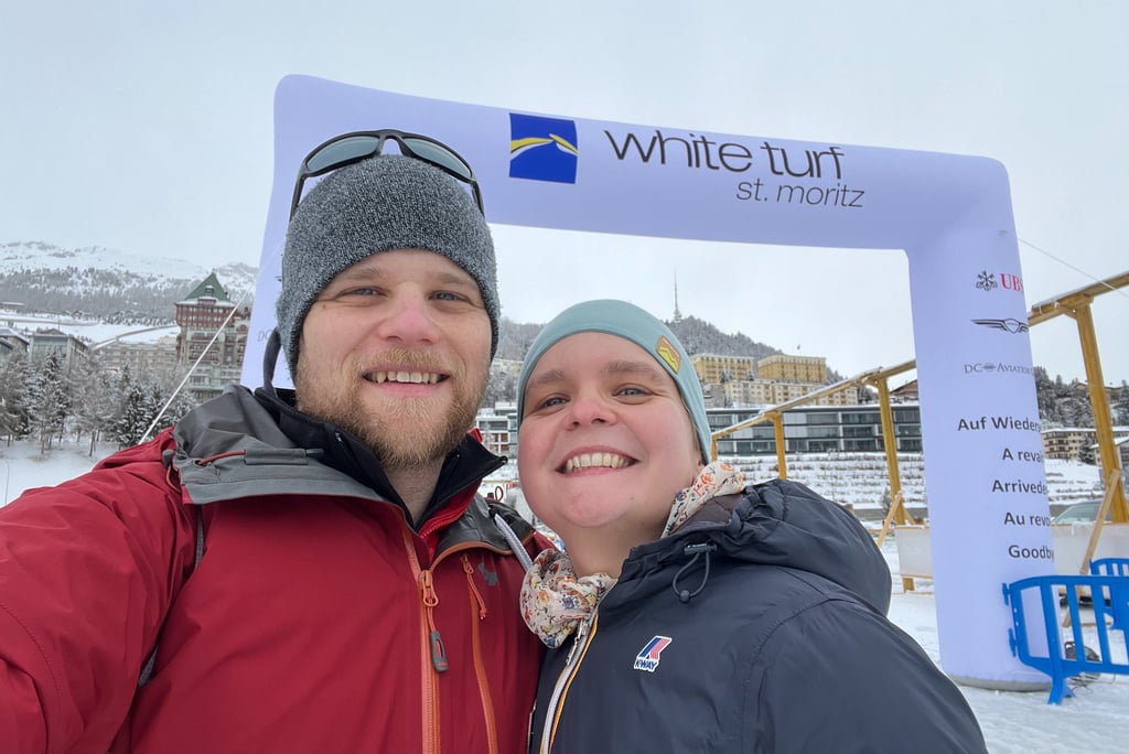 Colin and Corinne from Hidden Switzerland Travel in front of the entrance to the White Turf Horse Races in St. Moritz