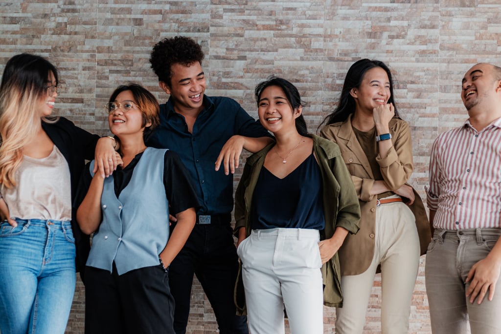 a group of people standing around a brick wall