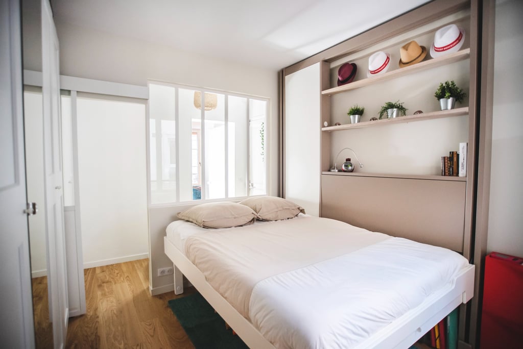 a bed with a white bed and a red suitcase