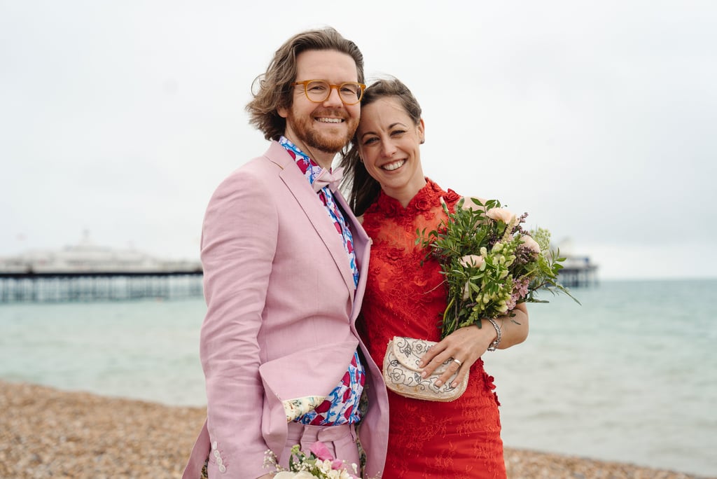 bride in red and groom in pink holding each other and smiling 
