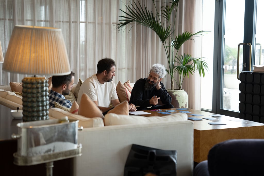 man talking to another man sitting on the sofa