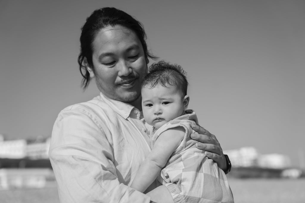 Black and white photo of father holding his baby in the arms