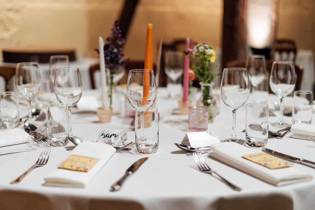 table with glasses  and name tags with colourful candles 
