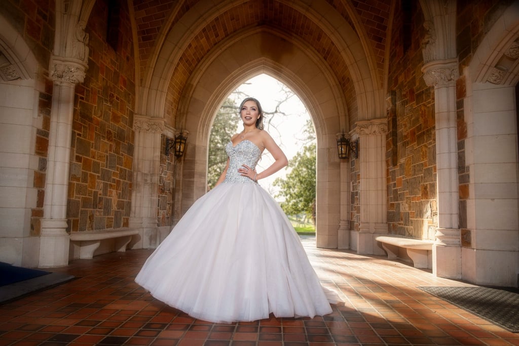 quinceanera in a white dress standing in a archway
