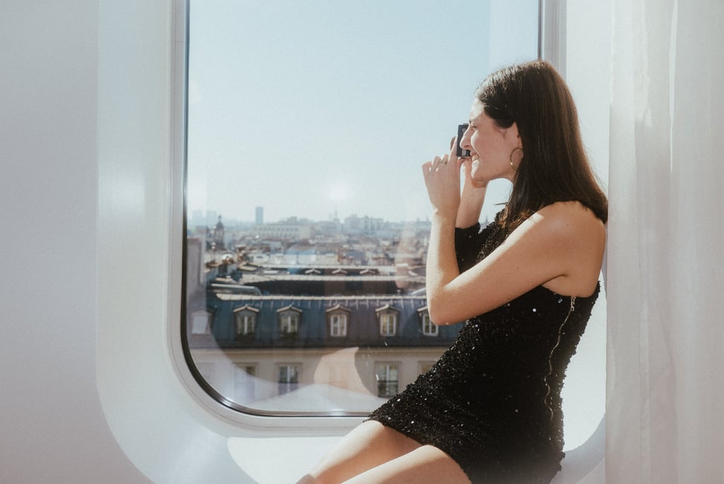 Femme prenant des photos dans une chambre de l'hôtel Renaissance Paris République