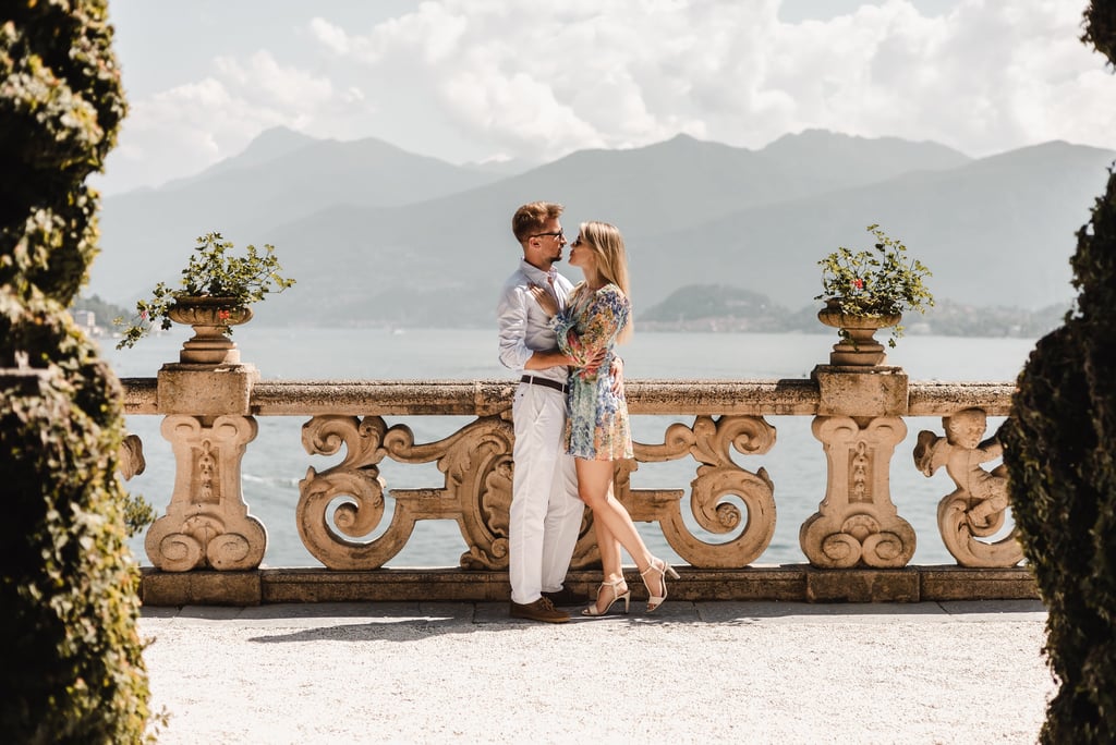 a couple kissing on a balcony overlooking the water at Villa Balbianello
