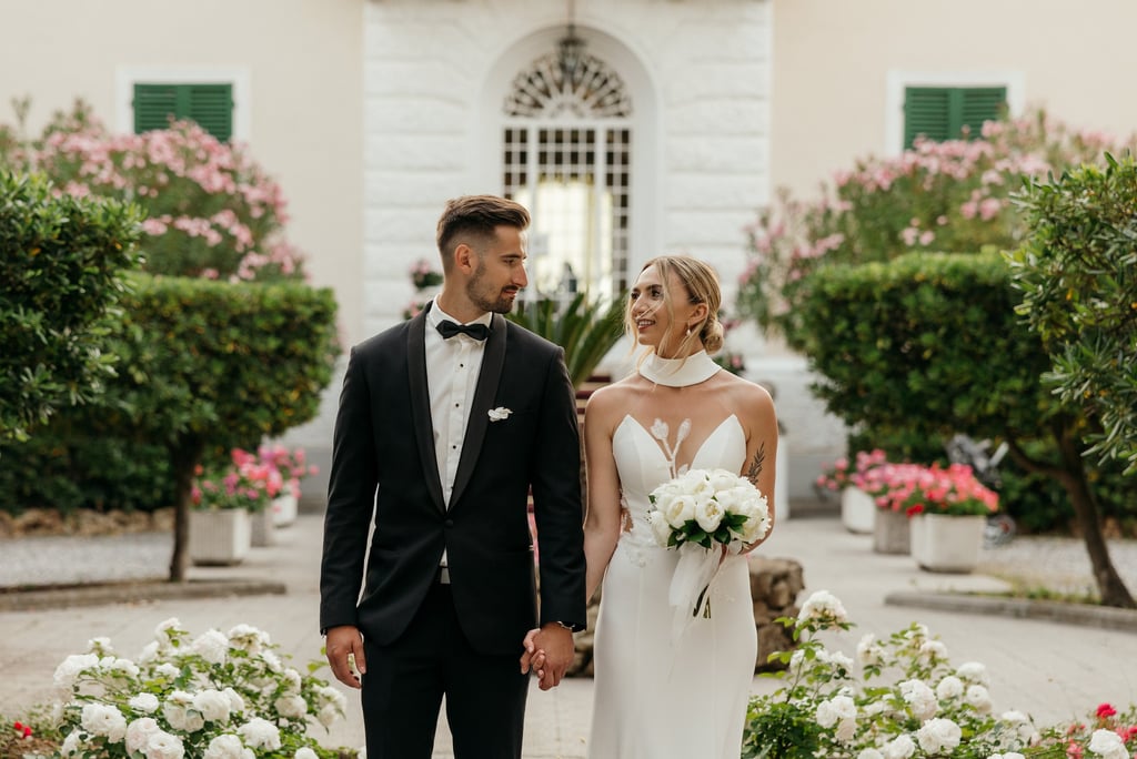 a bride and groom standing in front of a Grand Hotel Villa Parisi in Tuscany wedding