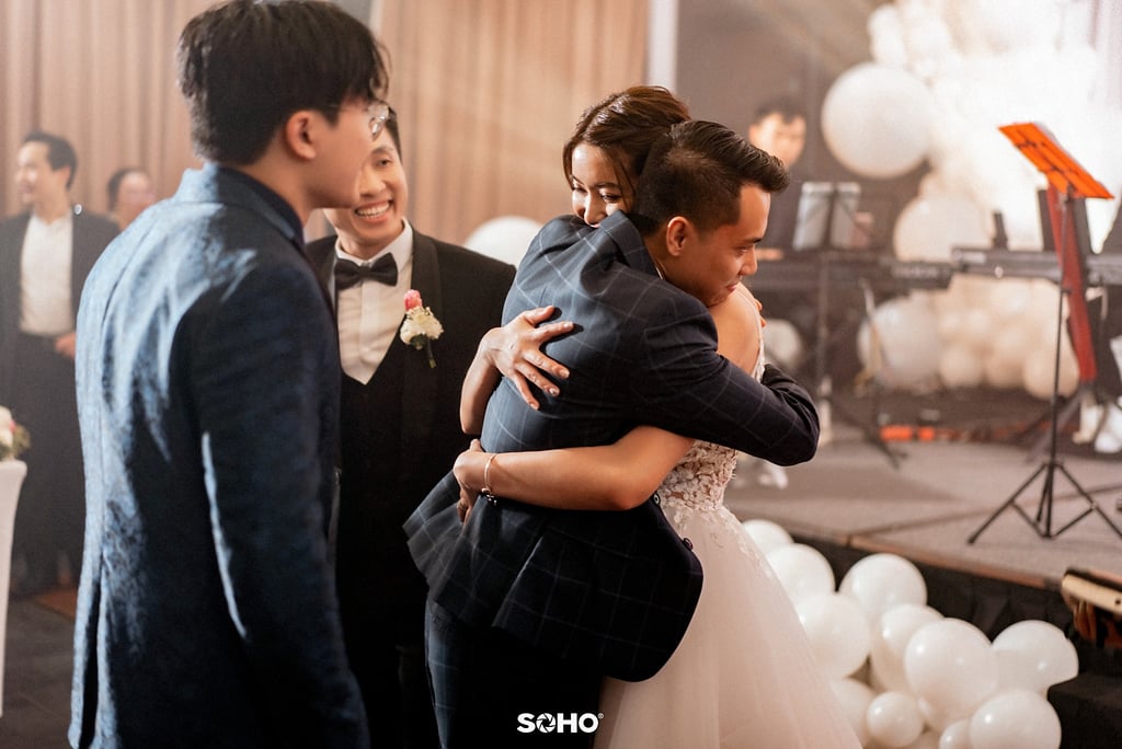 a bride and groom are hugging in a wedding ceremony