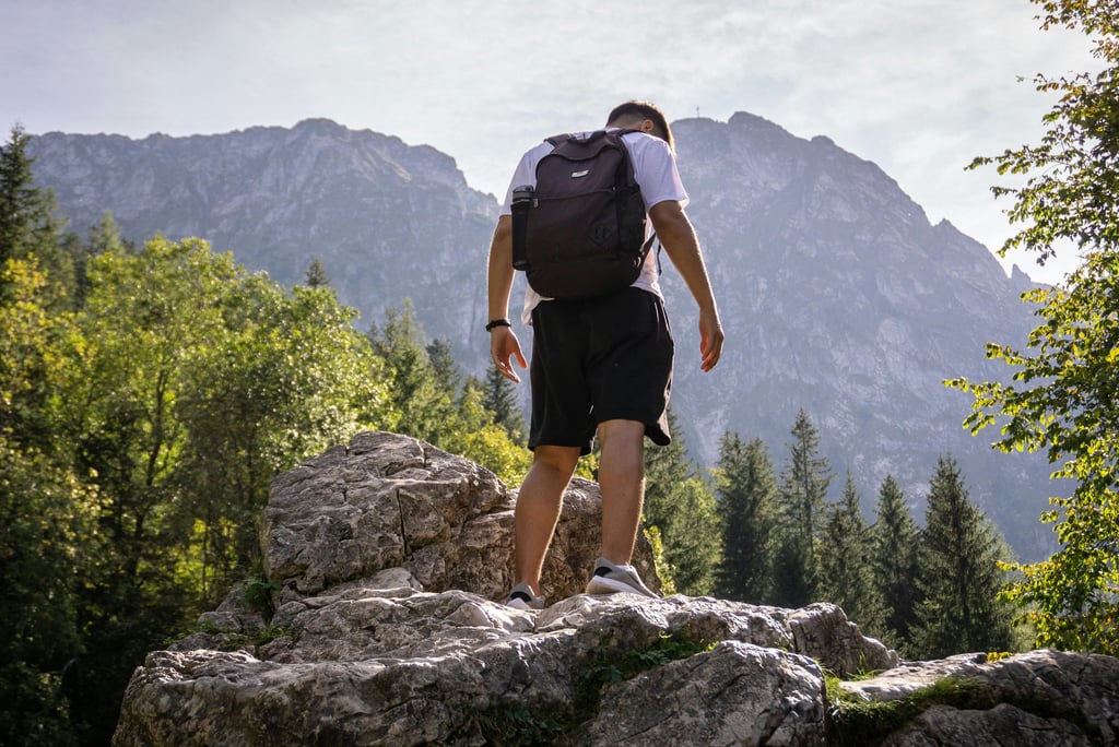 a man with a backpack on a rocky cliff. he is trying to keep himself healthy II