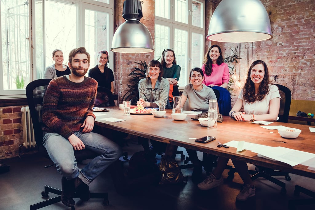 Ein Gruppenfoto an einem großen Gemeinschaftstisch.