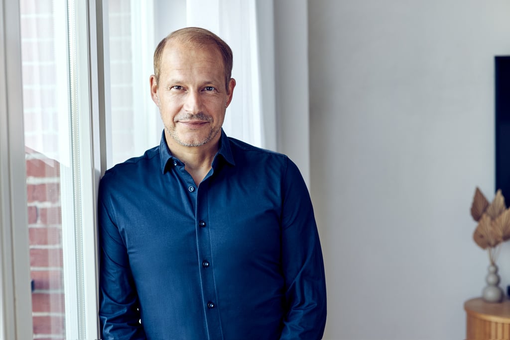 Tim Nidernolte in einem blauen Hemd neben einem Fenster.