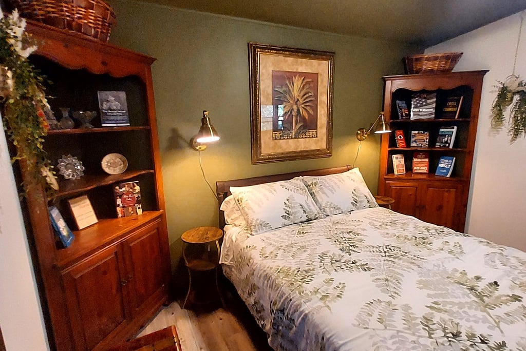 a bed room with a bed and a book shelf brass accents antique furniture