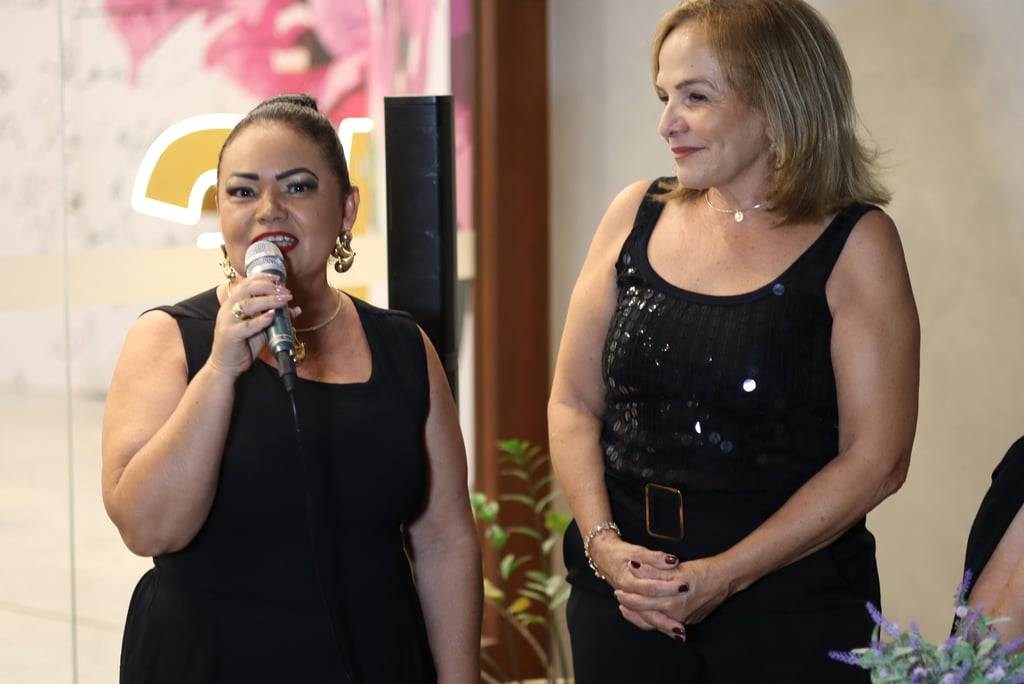 Duas mulheres de preto falando ao público