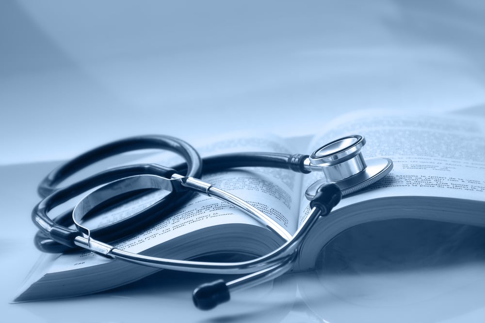 An open medical book with a stethoscope on top of it