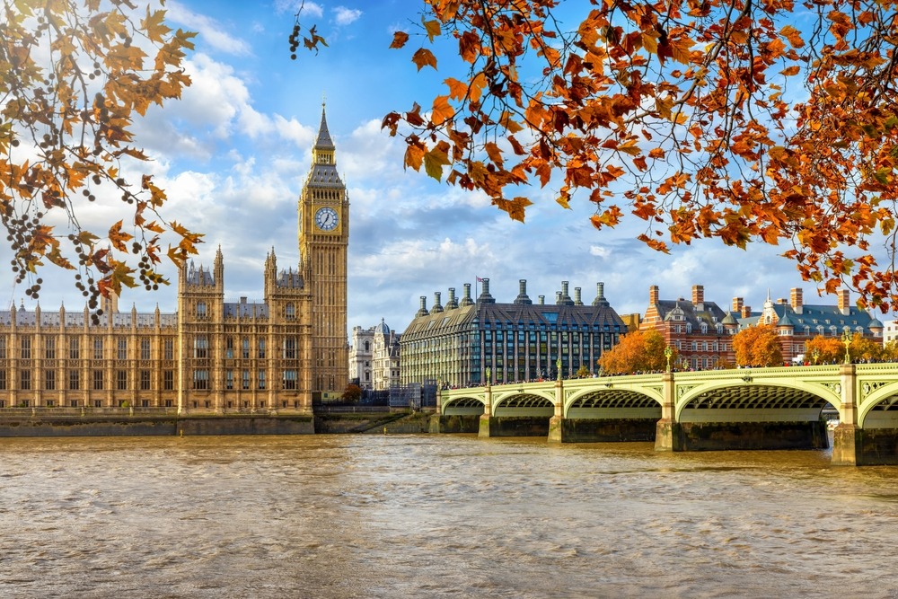 a bridge over a river with a clock tower in the background