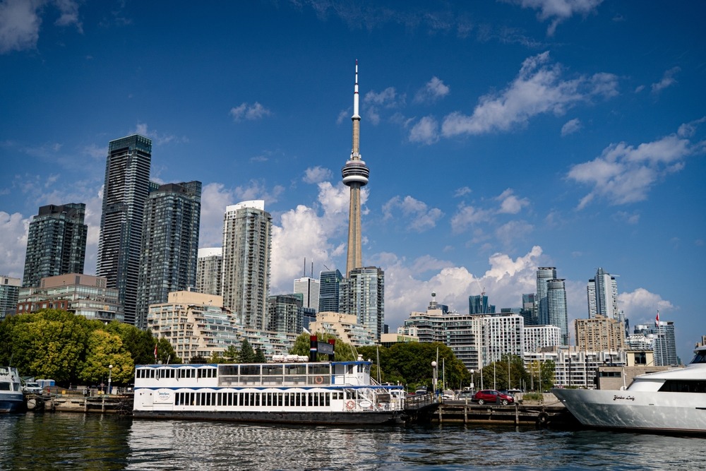 a boat on the water with a view of the toronto city