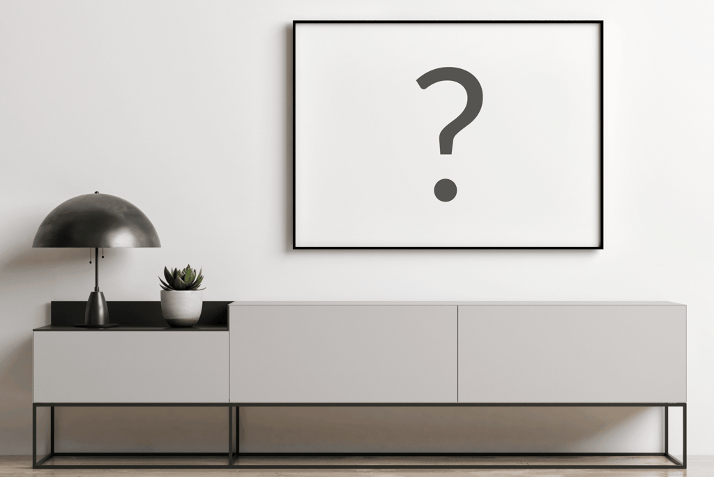 Modern minimalist interior with a black picture frame mockup over a grey sideboard cabinet.