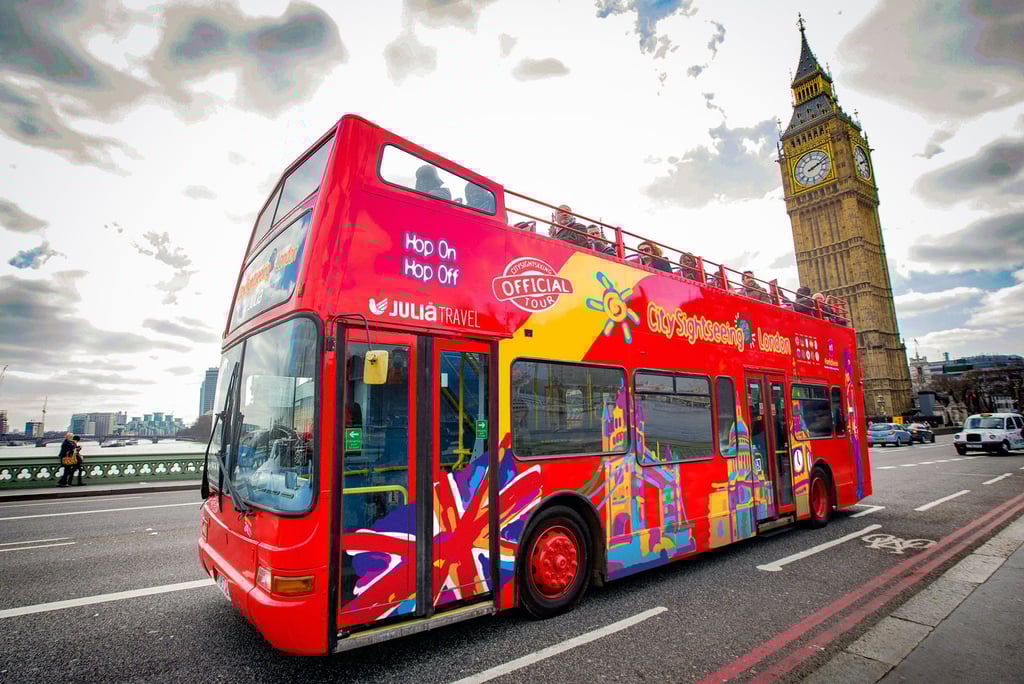 Red open-top double-decker bus in London with Big Ben in the background