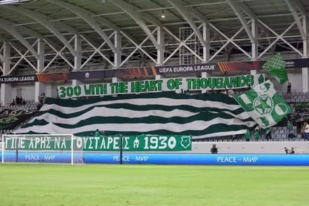 Ultras von Aris Limassol unterstützen ihr Team im Stadion mit Fahnen, Gesängen und Fan-Choreografie.