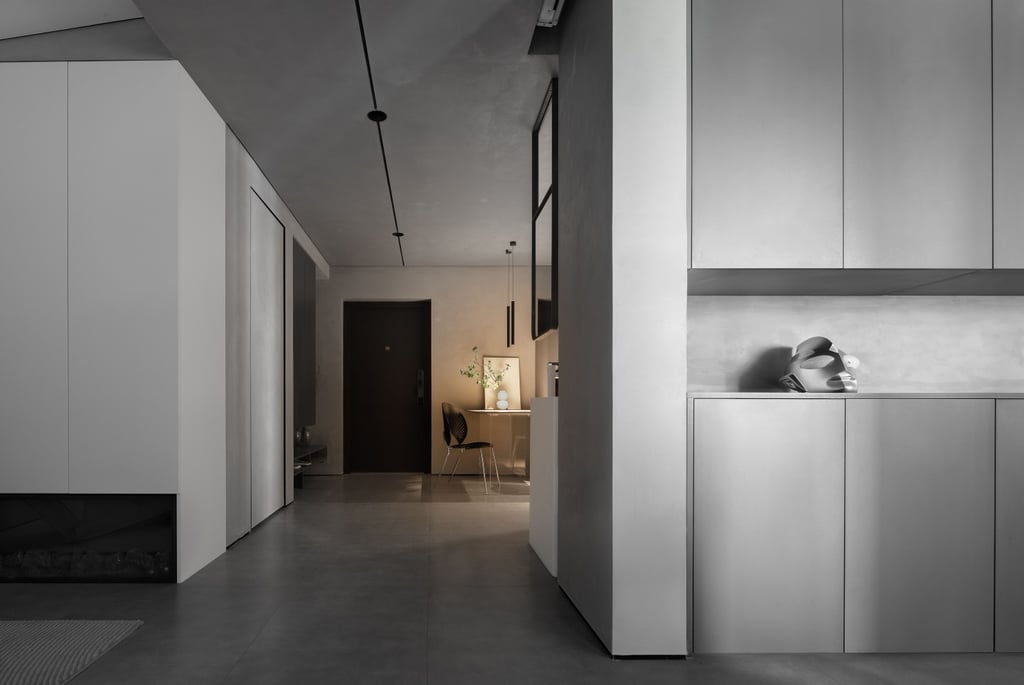A modern apartment featuring gray flooring, white cabinetry, and a dark doorway.