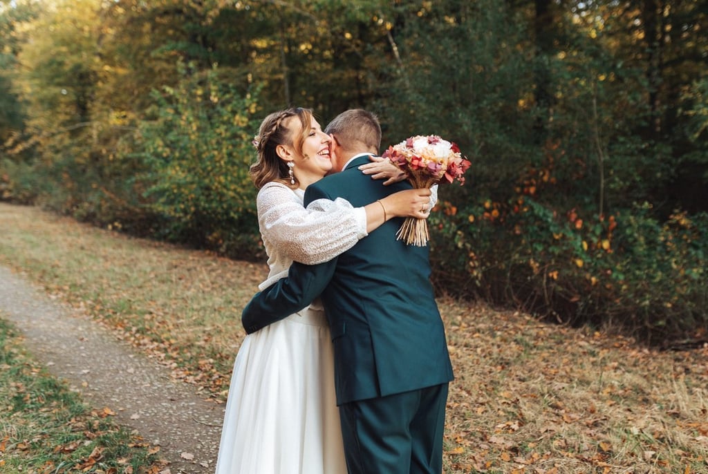 La mariée enlace son futur mari avec émotion lors de leur découverte en forêt.