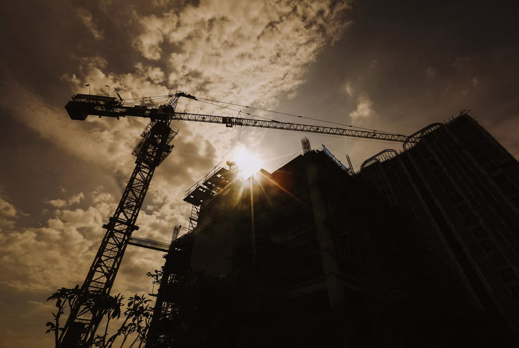 jasa photography jakarta, siluet of a crane and construction building is shown in the sun setting