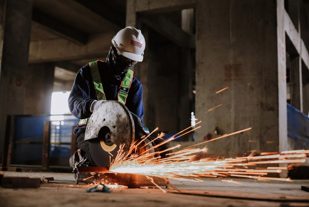 seorang pria mengenakan helm dan sedang metotong baja,jasa photography jakarta