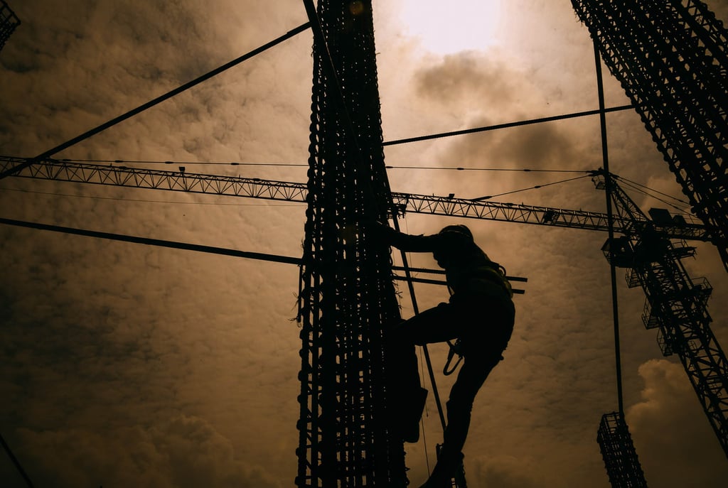 jasa photography jakarta, siluet crane and a person climbing a pole with a sky background