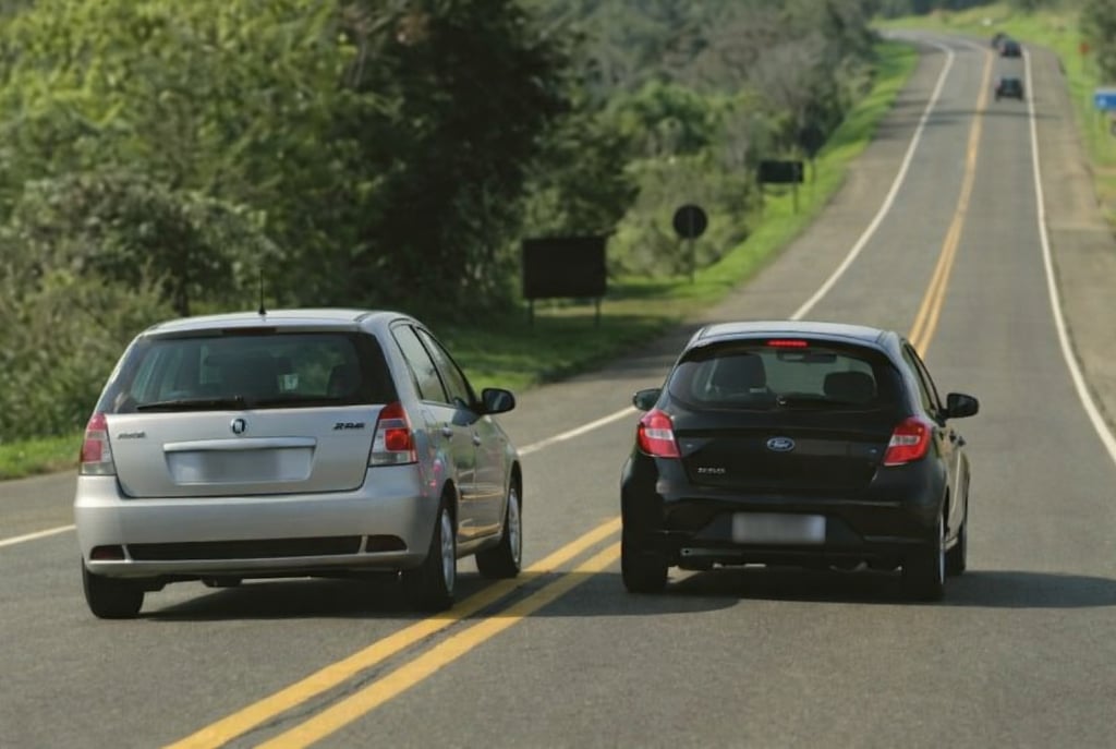 ultrapassagem em faixa contínua com carros brasileiros em rodovia de risco