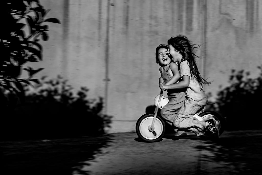 a little girl riding a tricycle in a black and white photo