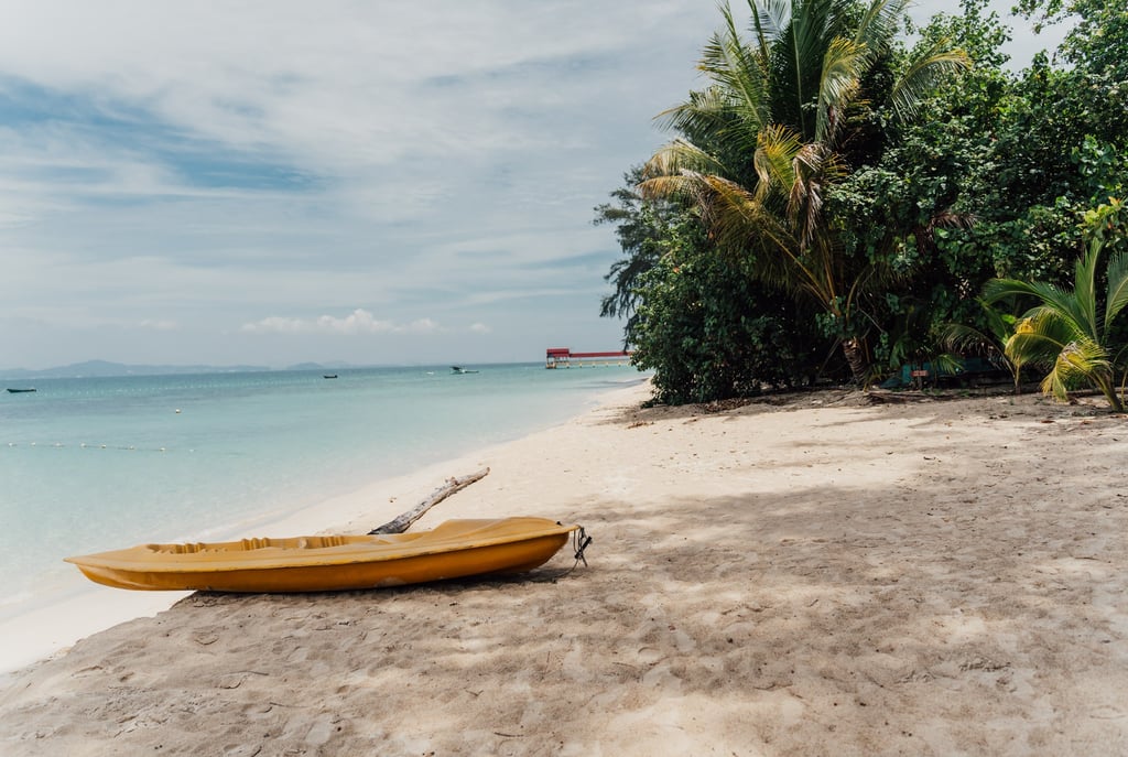 a yellow canoe sitting on the beach