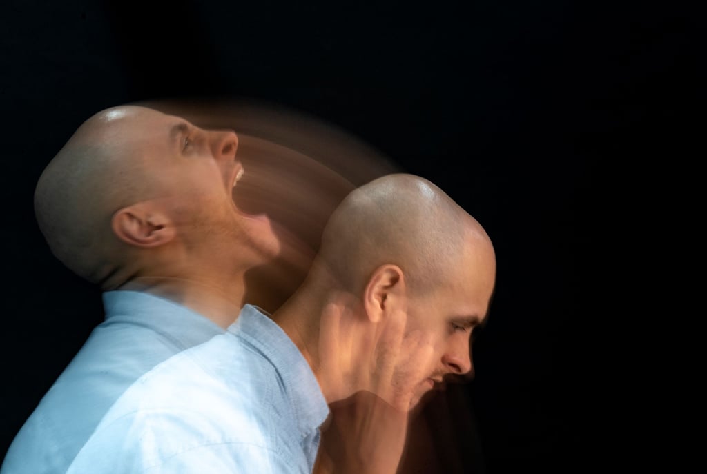 two bald men standing next to each other