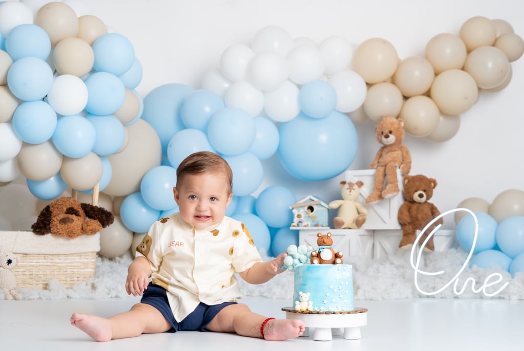 a baby boy in a blue and white cake smash cake