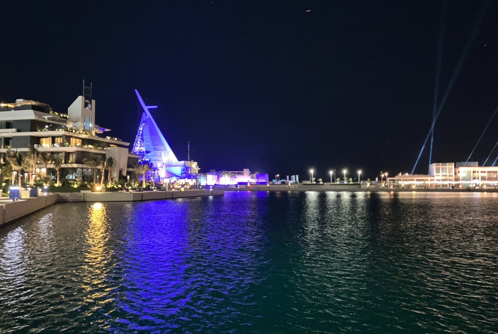 a boat in the water with a sailboat in Jeddah Corniche, Saudi Arabia