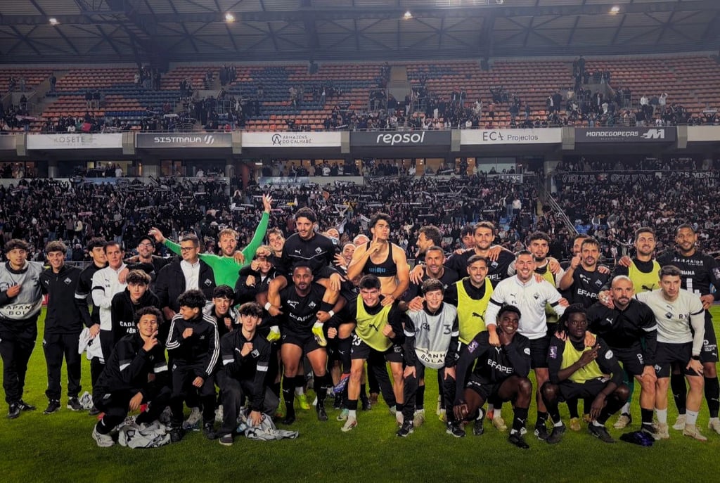 Académica de Coimbra football team celebrating a victory with their supporters