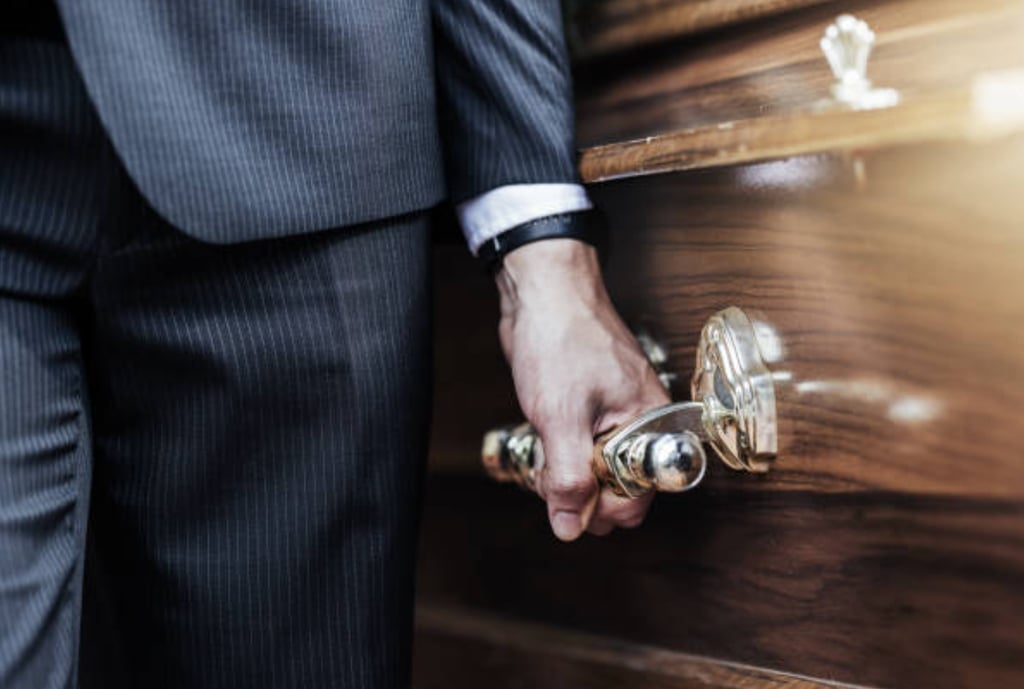 a close up of a pall bearer holding a coffin's handle