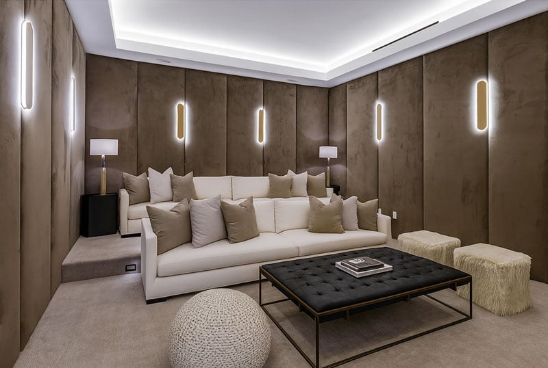 Luxurious home theater with custom wall panels, plush sofa, modern lighting, and stylish coffee table by Solo Home Decor.