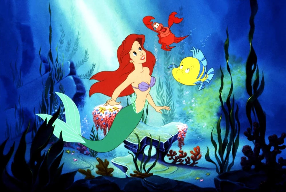 Ariel swims underwater with sea creatures in Disney’s The Little Mermaid (1989)