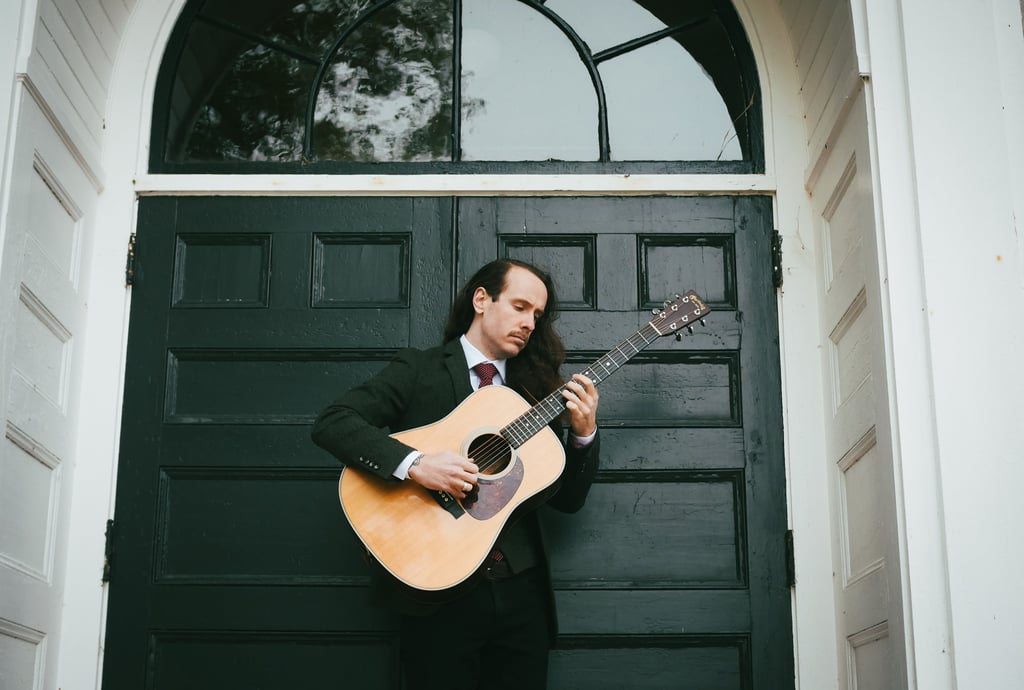 a man in a suit and tie playing guitar