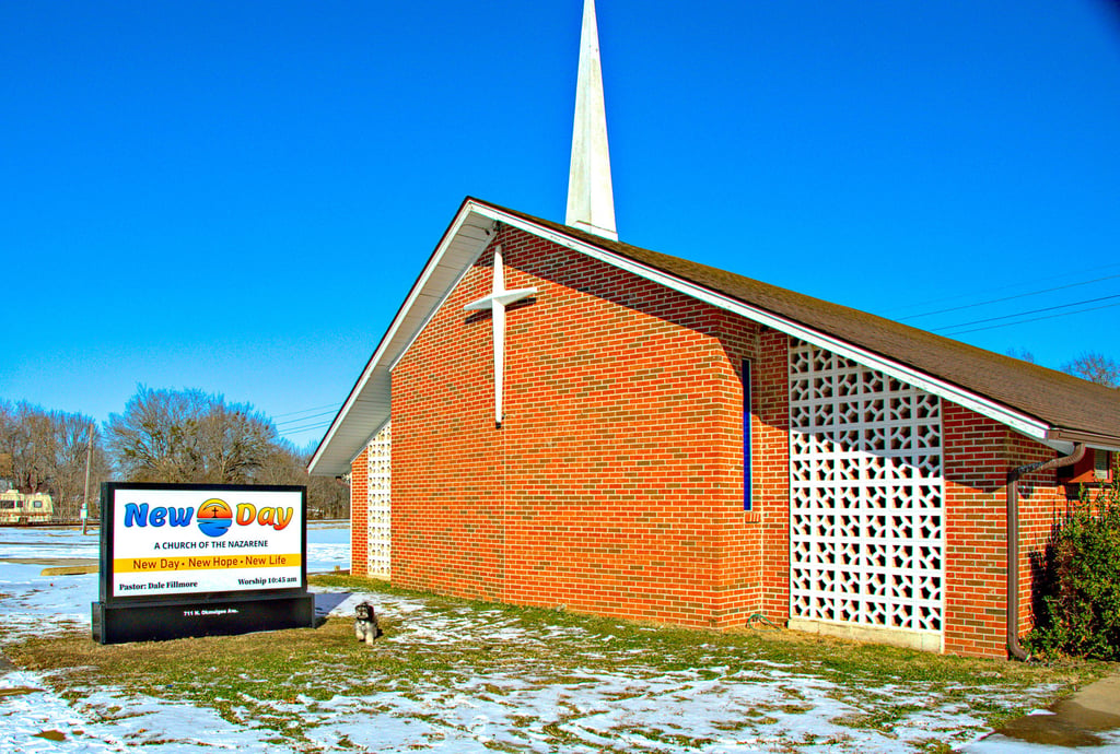Our church with our new sign, photobombed by the Pastor's dog, Scamp.