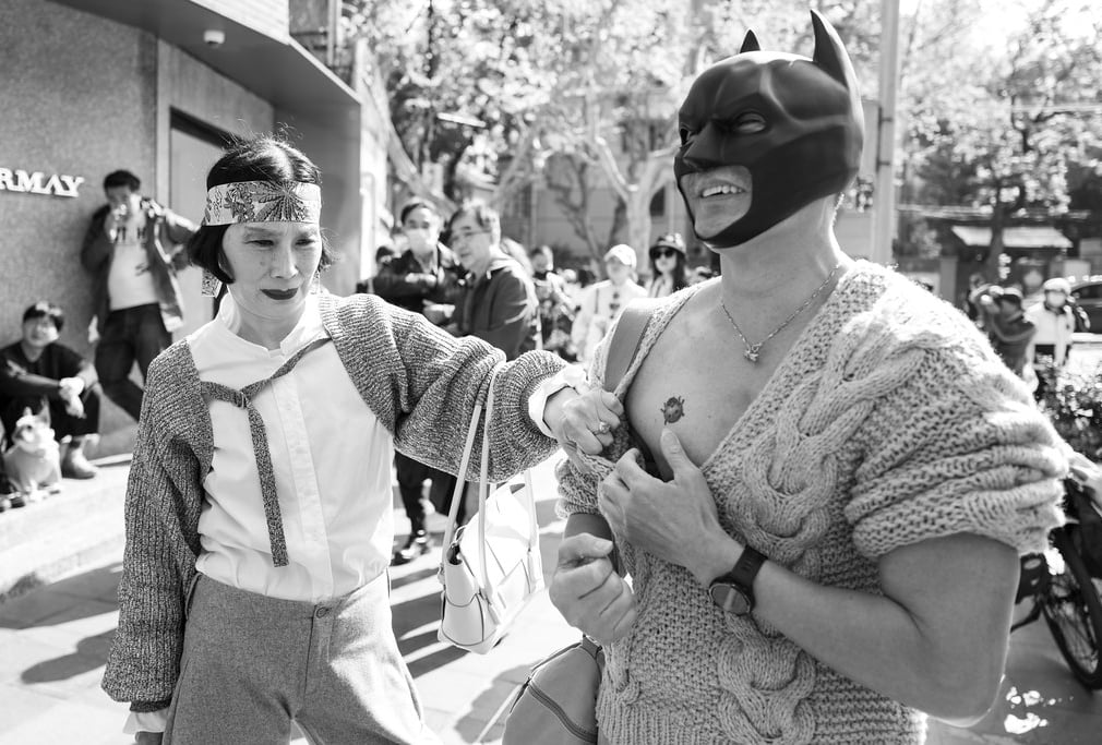 Man in Batman mask in Shanghai showing off his ladybird tattoo